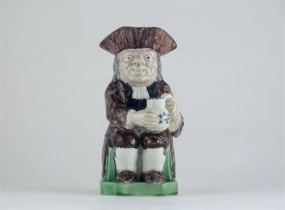 Appraisal: A Staffordshire pearlware Toby jug seated wearing a brown coat