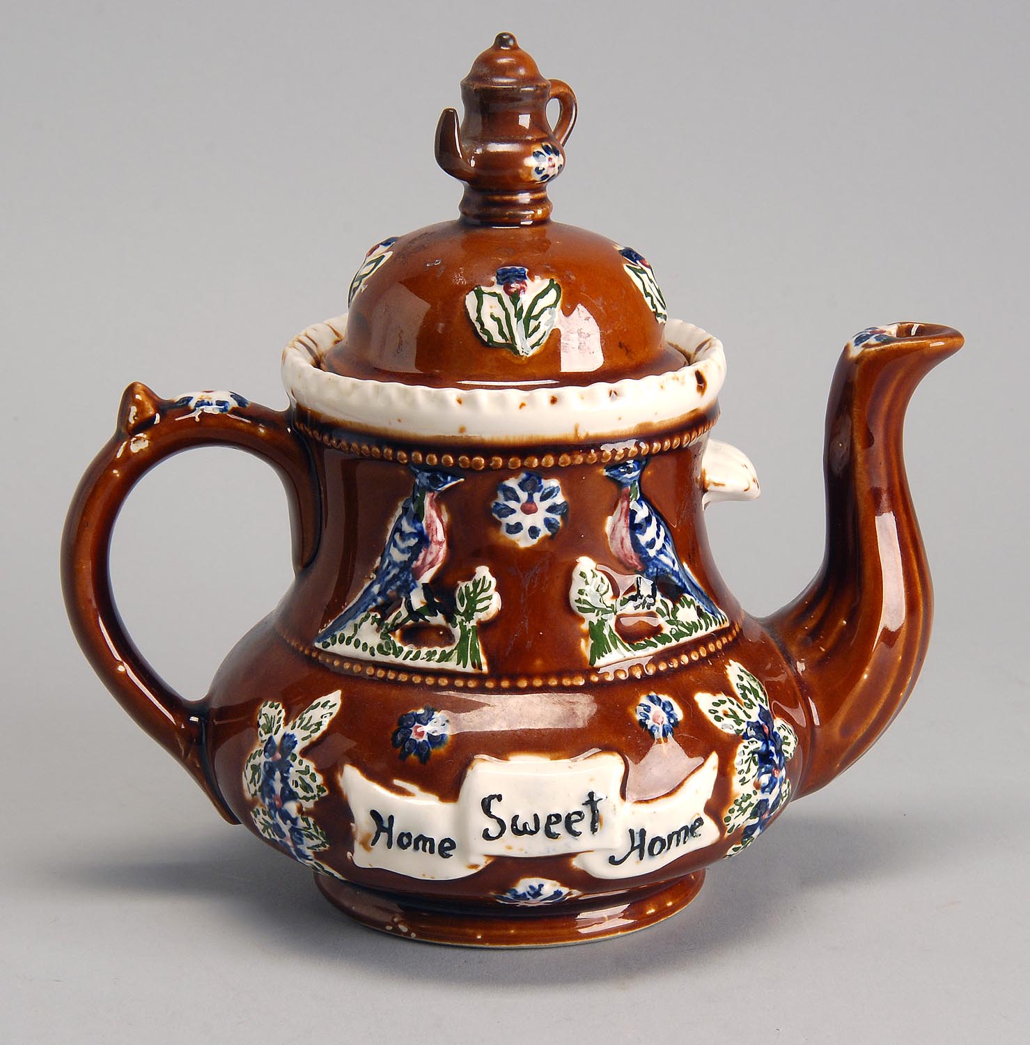 Appraisal: BARGE WARE TEAPOT in brown glaze with raised floral decoration