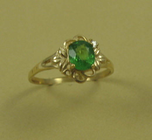 Appraisal: TSAVORITE DIAMOND AND FOURTEEN KARAT GOLD RING centering an oval-cut