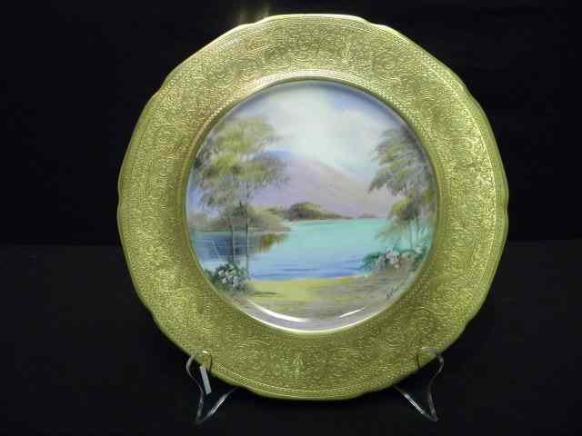 Appraisal: Decorative hand painted porcelain plate with wide gold band on