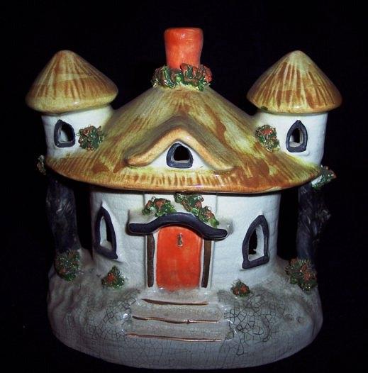 Appraisal: A Staffordshire pastille burner a thatched cottage with central orange