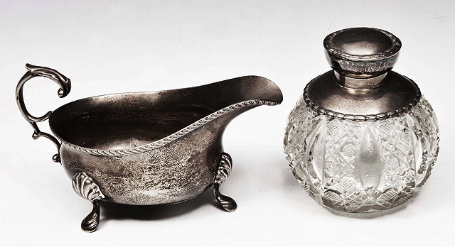 Appraisal: A SILVER SAUCE BOAT with gadrooned edge open scroll handle