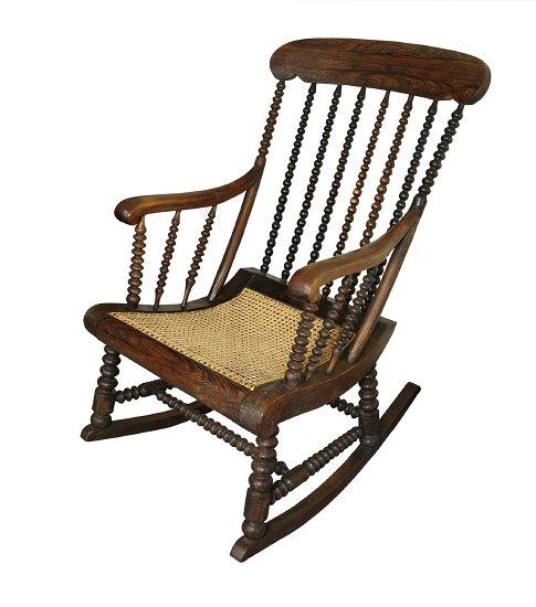 Appraisal: A rosewood cane seat rocking chair with bobbin turned upright