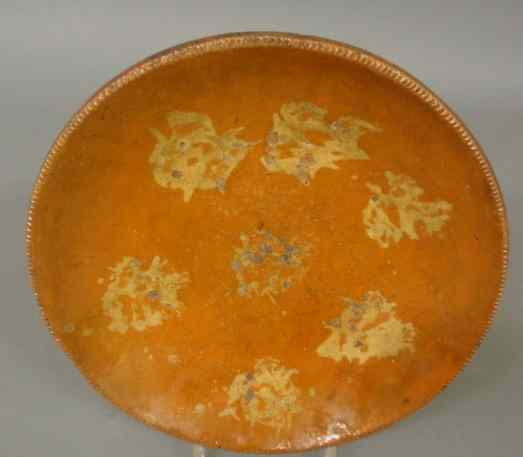 Appraisal: Pennsylvania redware plate th c with yellow slip decoration dia