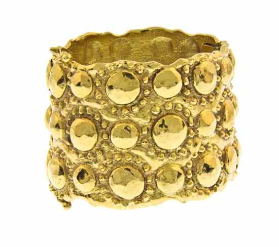 Appraisal: A Chanel Textured Goldtone Hinged Cuff Bracelet allover hammered circular