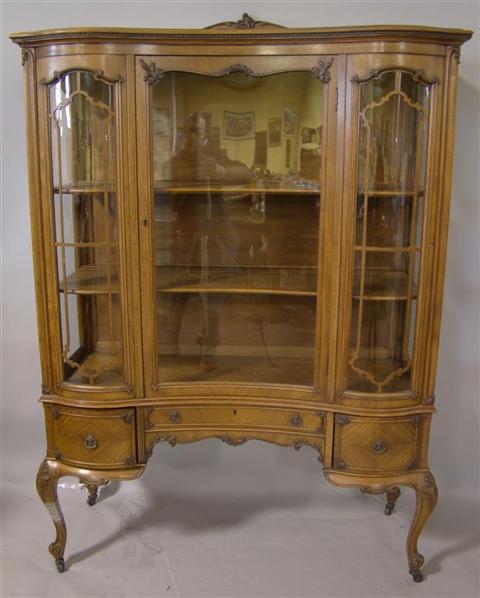 Appraisal: FRENCH PROVINCIAL STYLE CHINA CABINET The shaped cabinet with hinged