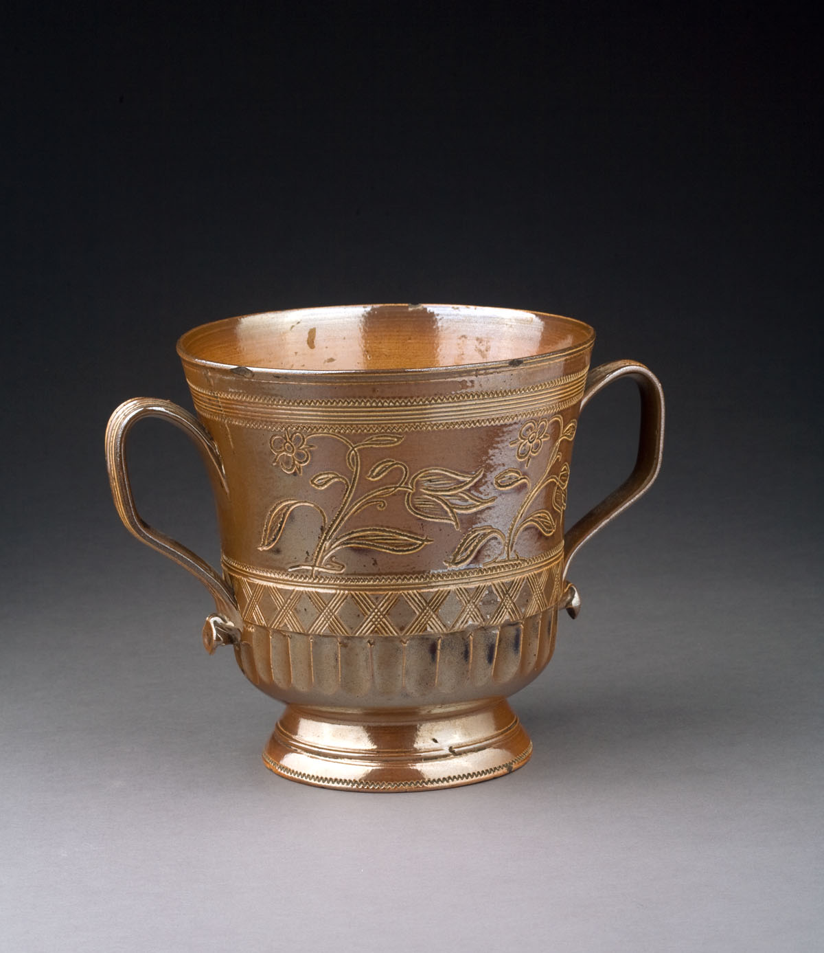 Appraisal: STAFFORDSHIRE BROWN-GLAZED RED EARTHENWARE LOVING CUP DATED Incised at the