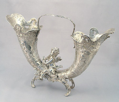 Appraisal: CONTINENTAL SILVER CHERUBIC DOUBLE CORNUCOPIA VASE Basket handle double vase