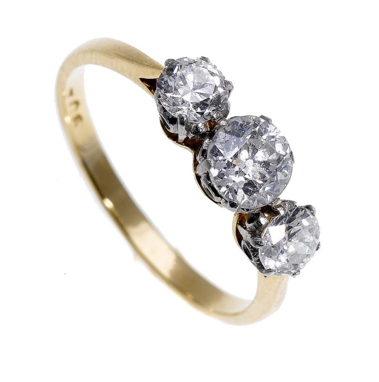 Appraisal: A DIAMOND THREE-STONE RING with larger central and pair of