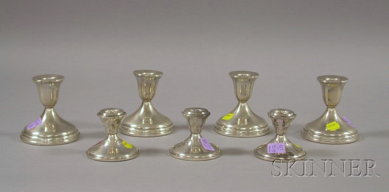 Appraisal: Seven Silver Weighted Low Candlesticks a set of four and