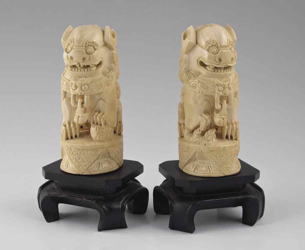 Appraisal: PAIR CARVED IVORY FU LIONS th c pair of uniformly-toned