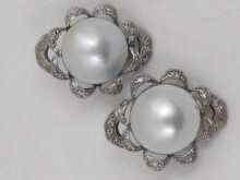 Appraisal: A pair of white metal tests silver earclips set with