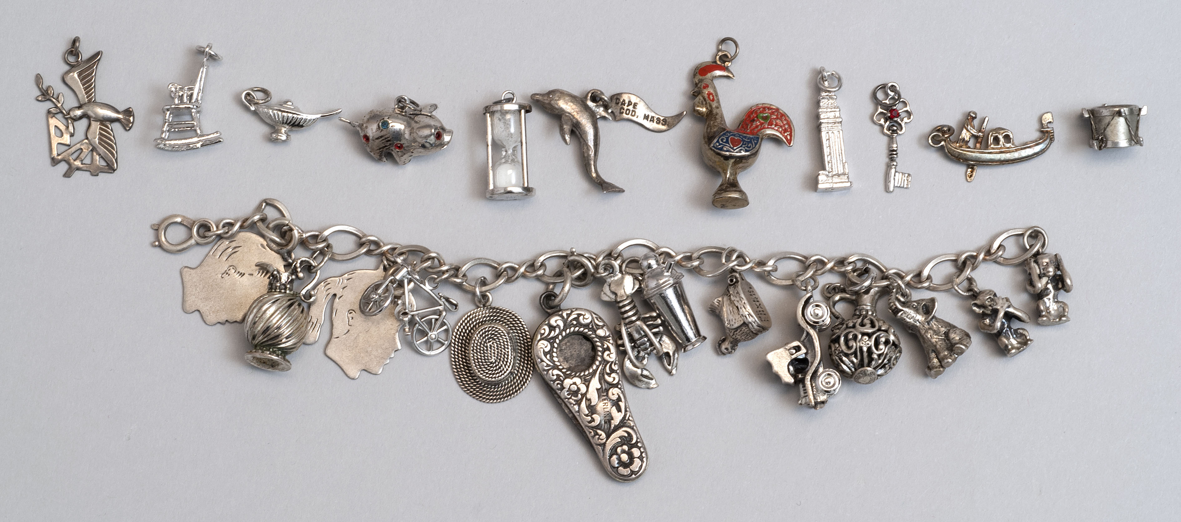 Appraisal: STERLING SILVER CHARM BRACELET Mounted with fourteen silver charms Together