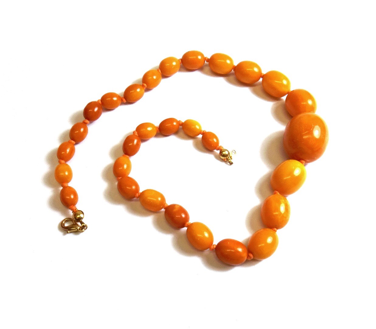 Appraisal: A single row necklace of graduated oval vary coloured butterscotch