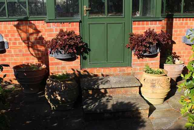 Appraisal: A PAIR OF TERRACOTTA PLANTERS of tapering form with three