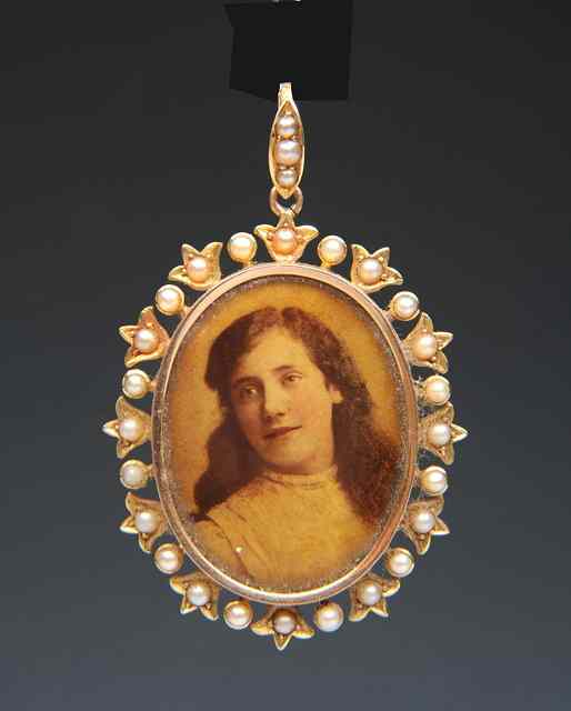 Appraisal: AN EDWARDIAN OVAL LOCKET with pearl set outer frame and