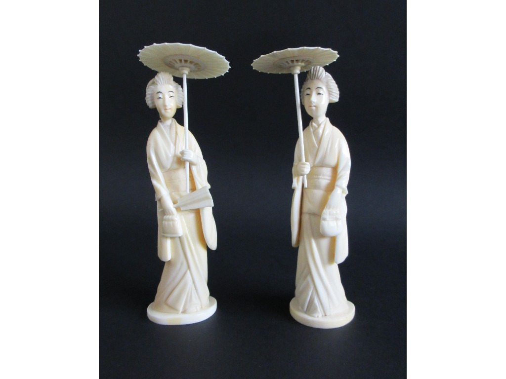 Appraisal: A pair of Japanese carved ivory figures of ladies holding