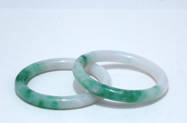 Appraisal: Pair of matching green jadeite bangle bracelets spinach color MEASUREMENTS