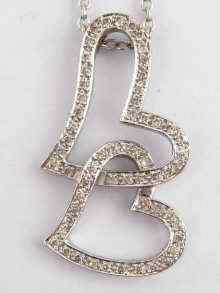 Appraisal: A white metal tests carat gold double heart diamond pendant