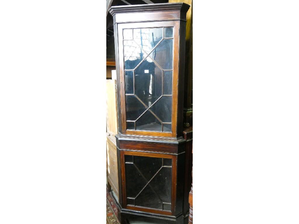 Appraisal: An Edwardian mahogany two tier freestanding corner cabinet enclosed by