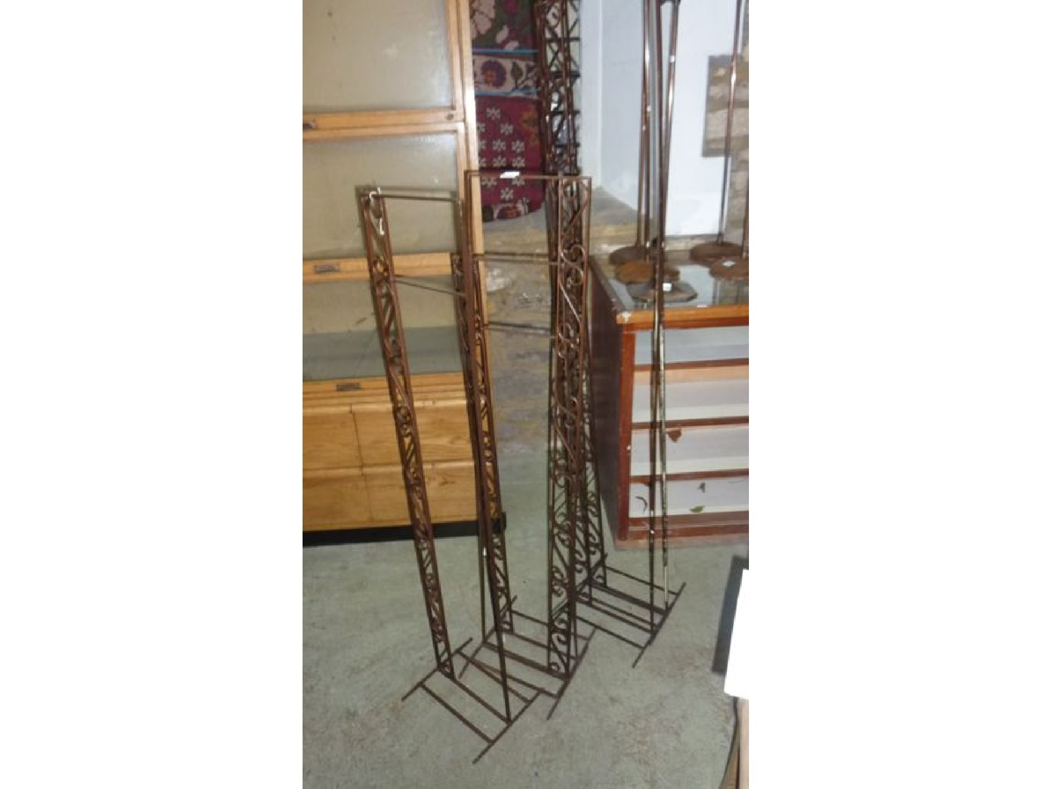 Appraisal: Five simple painted steel floorstanding shop display stands with scrollwork