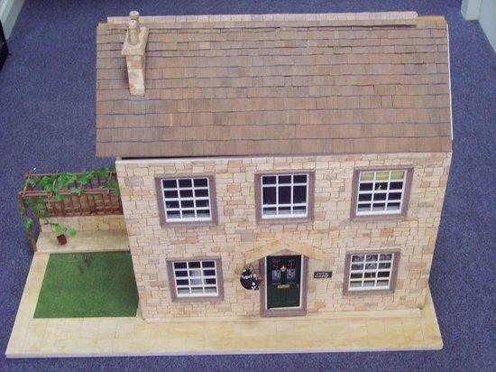 Appraisal: A Cotswold style doll's house together with a large quantity