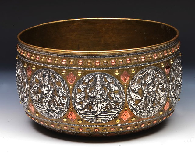 Appraisal: AN INDIAN CIRCULAR BRASS AND COPPER BOWL with silvered deity