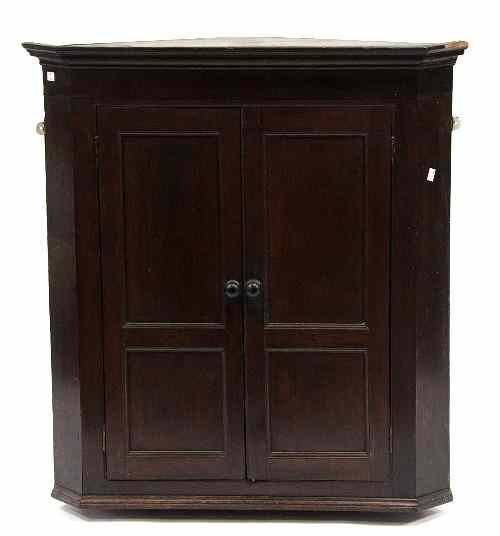 Appraisal: A th Century corner cupboard the panelled doors enclosing shelves