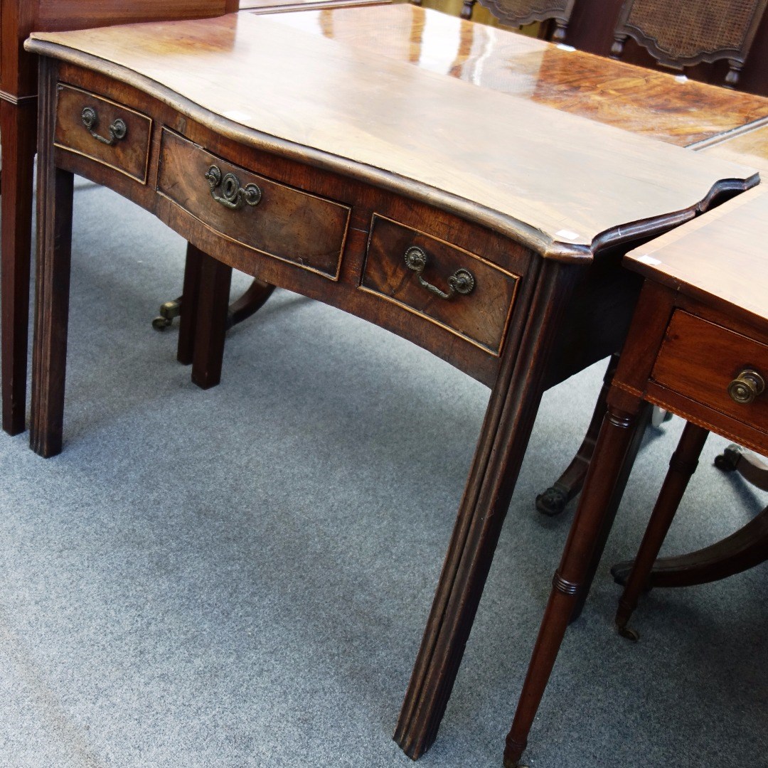 Appraisal: An th century serpentine mahogany three drawer side table on