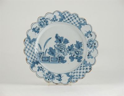 Appraisal: A Delftware plate with a scalloped rim painted in blue