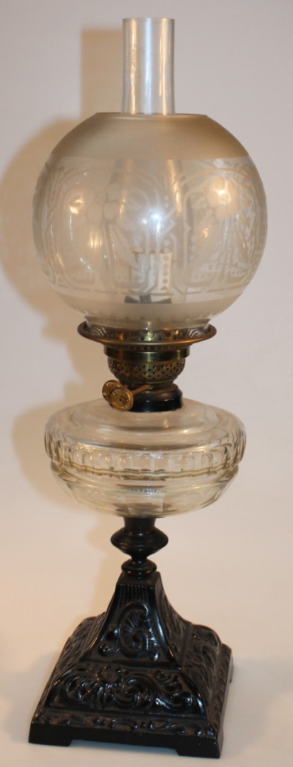 Appraisal: An Edwardian metal frame oil lamp with plain glass chimney