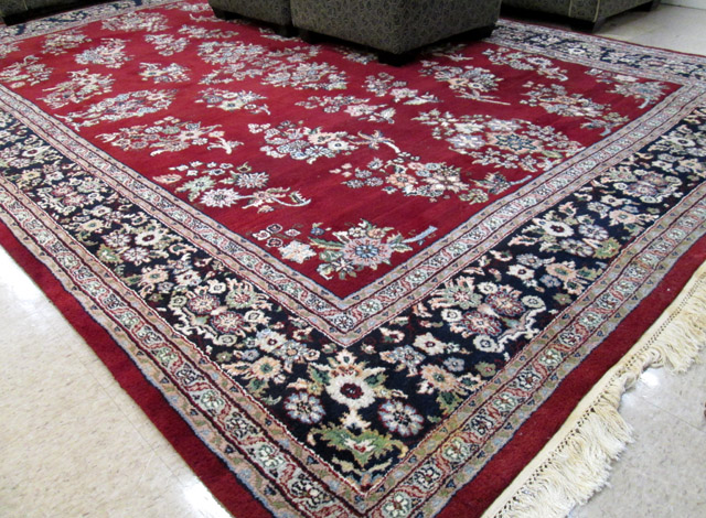 Appraisal: HAND KNOTTED ORIENTAL CARPET Indo-Sarouk the red wine ground decorated