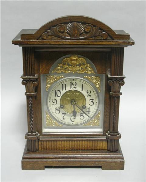 Appraisal: AN OAK MANTEL CLOCK The white metal chapter ring within