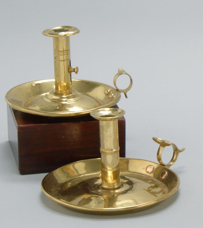 Appraisal: TWO SIMILAR AMERICAN BRASS PUSH-UP CHAMBERSTICKS th CenturyWith saucer bases