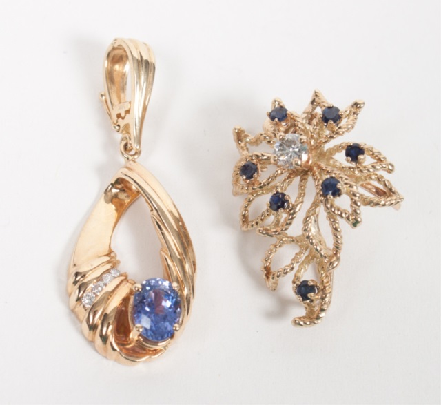 Appraisal: Two K gold diamond and other stone pendants one modelled