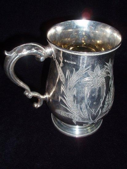 Appraisal: A tankard of baluster shape with scrolling handle the beaded