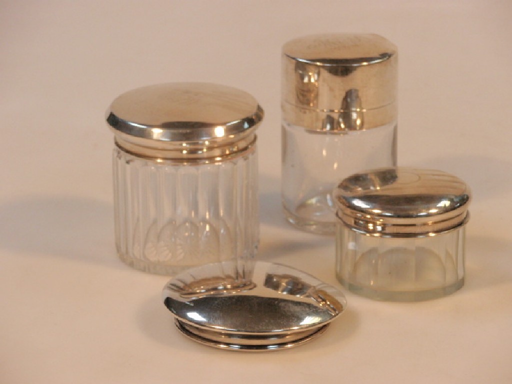 Appraisal: Three silver topped dressing table jars and a silver lid