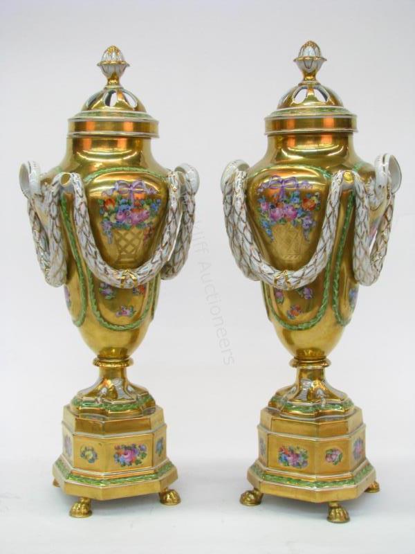 Appraisal: A pair of Dresden porcelain lidded handled urns with gold