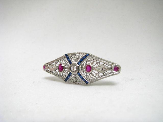 Appraisal: Vintage platinum filigree pin with diamonds sapphires and rubies