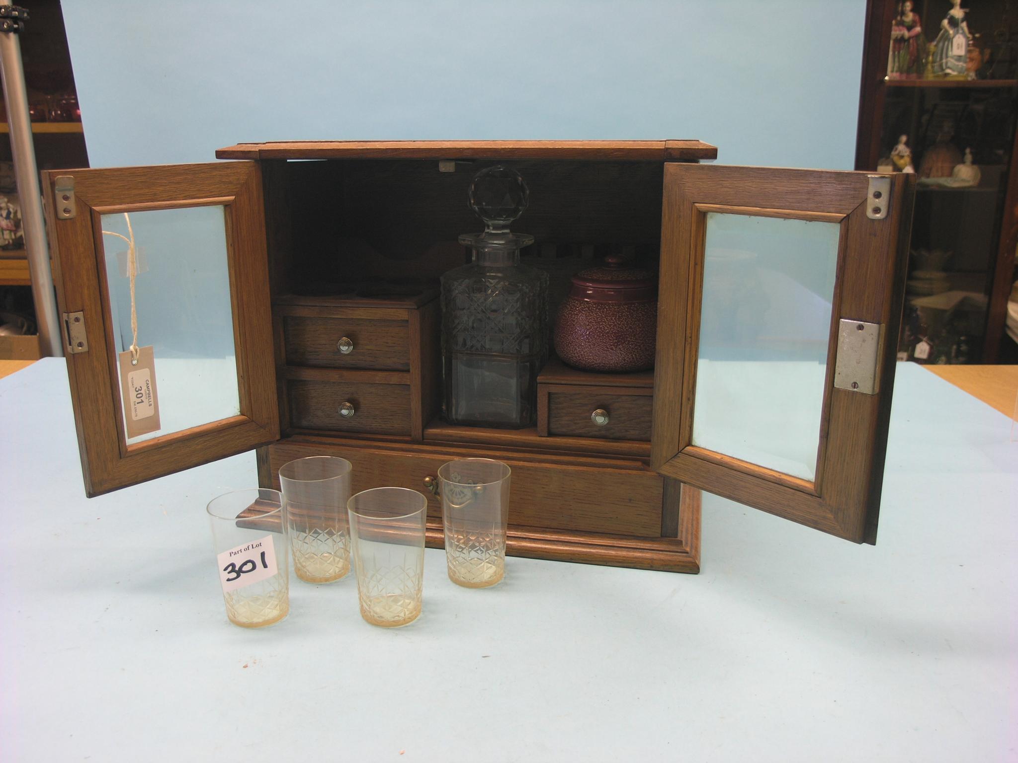 Appraisal: An oak drinks-tobacco compendium fitted interior contains cut glass decanter