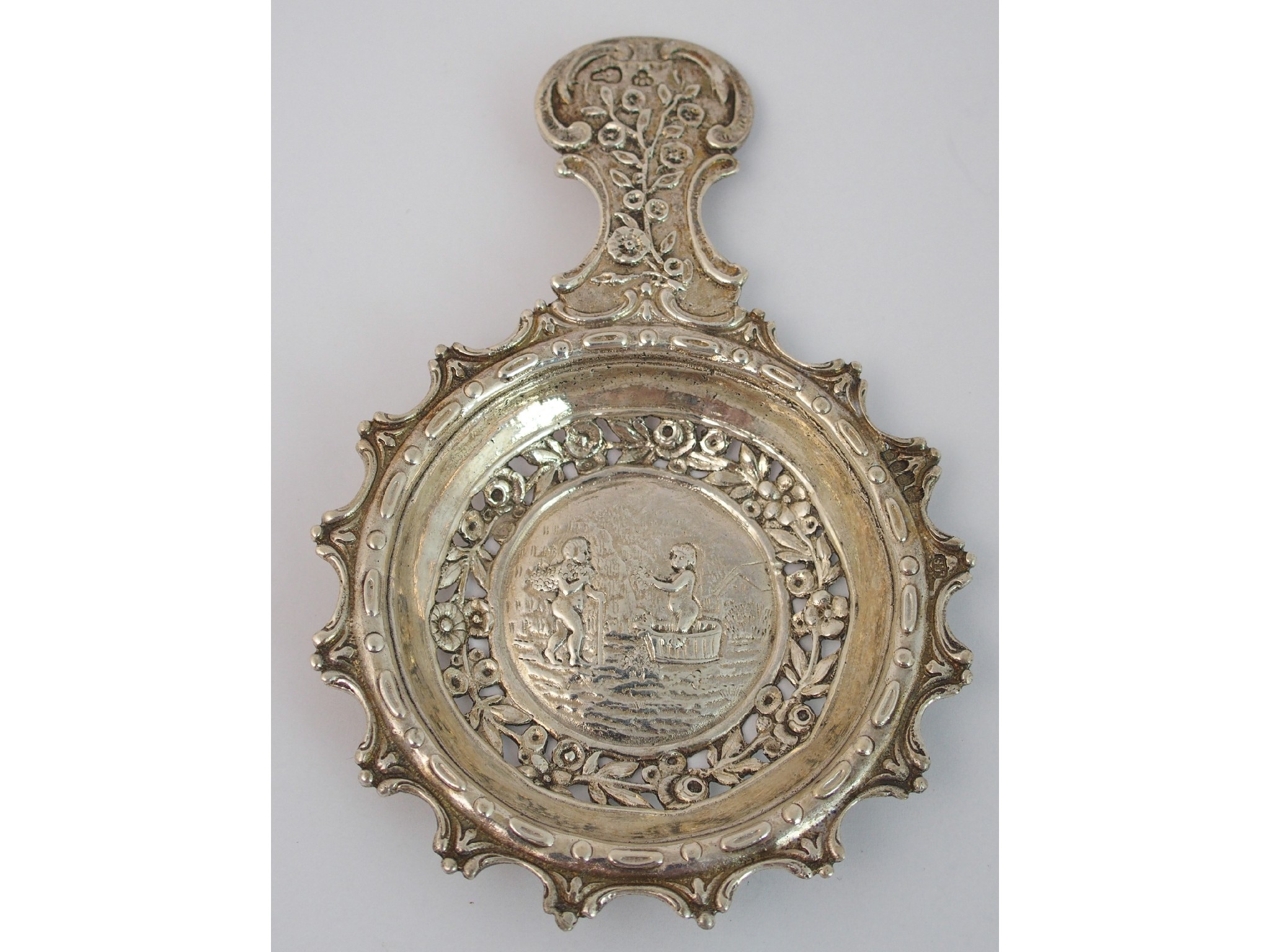 Appraisal: A continental white metal strainerwith foliate decoration the bowl with