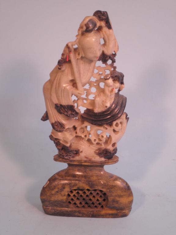 Appraisal: A Chinese soapstone carving of an immortal beside a smaller