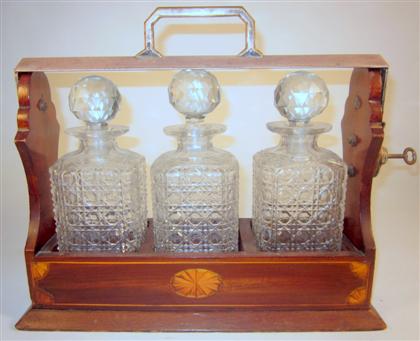 Appraisal: Edwardian mahogany and fruitwood inlaid tantalusThe three cut glass bottles