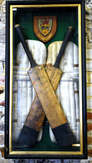 Appraisal: A cased display of two vintage cricket bats and pads