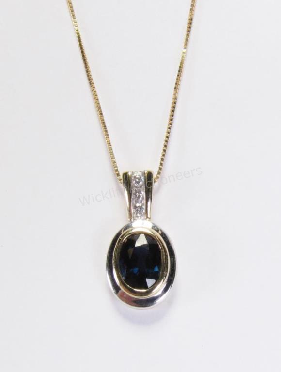 Appraisal: A K yellow gold pendant with oval bezel set sapphire