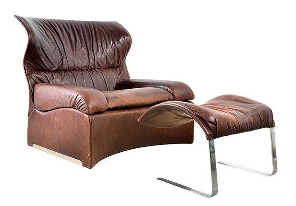 Appraisal: AN ITALIAN SAPORITI BROWN LEATHER ARMCHAIR AND MATCHING OTTOMAN A