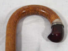 Appraisal: A wooden umbrella or cane handle set with red amber