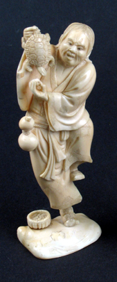 Appraisal: A JAPANESE OKIMONO IVORY CARVING of a man standing on