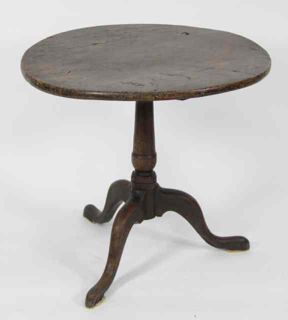 Appraisal: A George III elm circular table raised on a turned