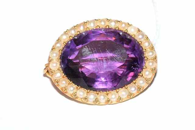 Appraisal: AN AMETHYST AND PEARL BROOCH oval facet cut amethyst surrounded